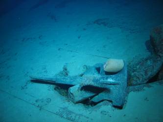 Stbd anchor embedded in steel plate from ship's side in debris field